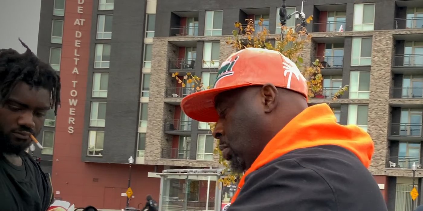T’Shaka Sankofa in his orange cap, handing out food on a Washington, DC street, a moment from the film
